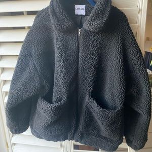 I Am Gia. Oversized black teddy coat.